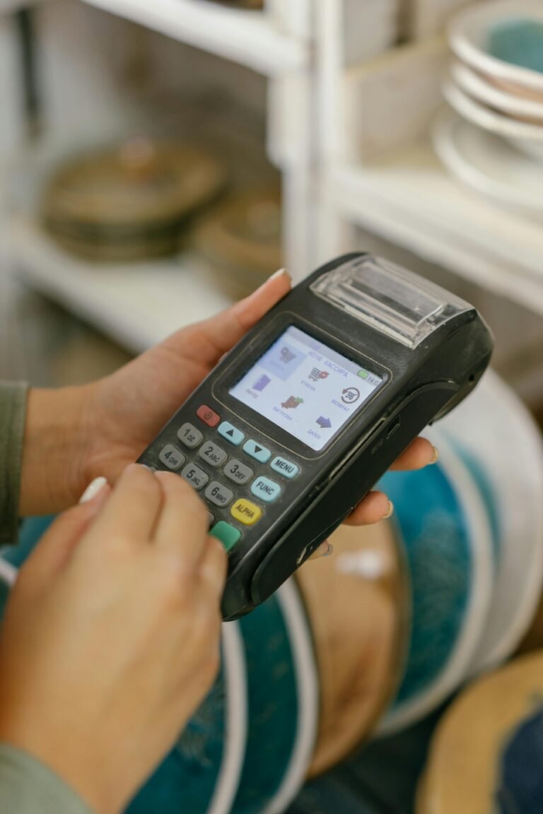 Hands operating a POS machine for payment processing in a retail setting.